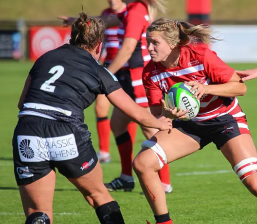 A group of women playing rugbyAI-generated content may be incorrect.