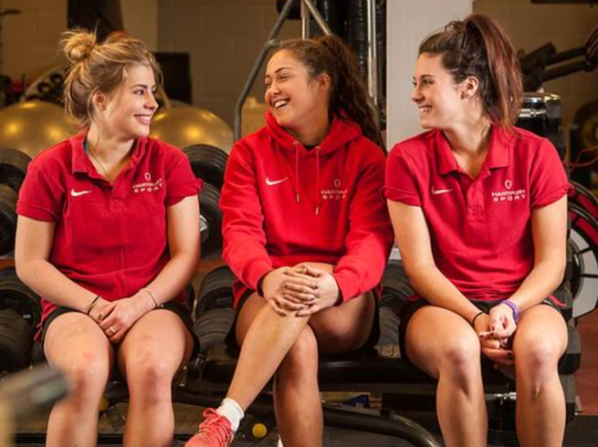 A group of women in red shirtsAI-generated content may be incorrect.