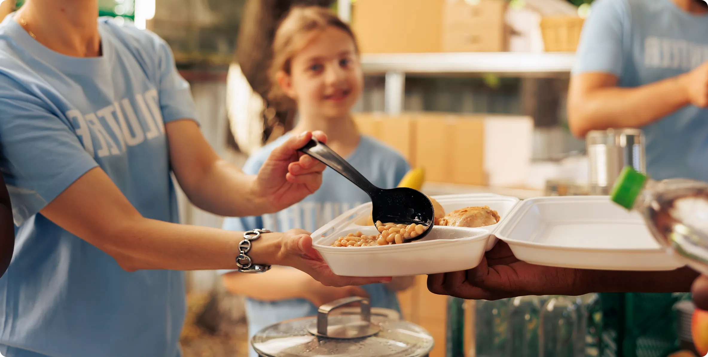 Volunteers serving freshly prepared meals to families affected by a natural disaster during an emergency relief response.