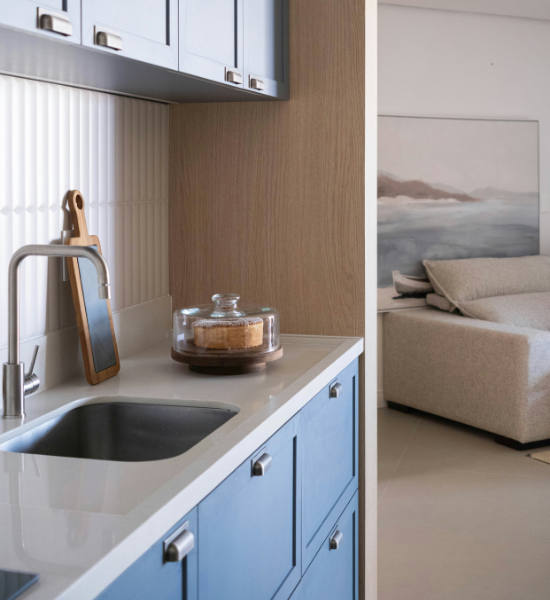 Quartz countertop remnant used for a compact wet bar with blue cabinetry and sink