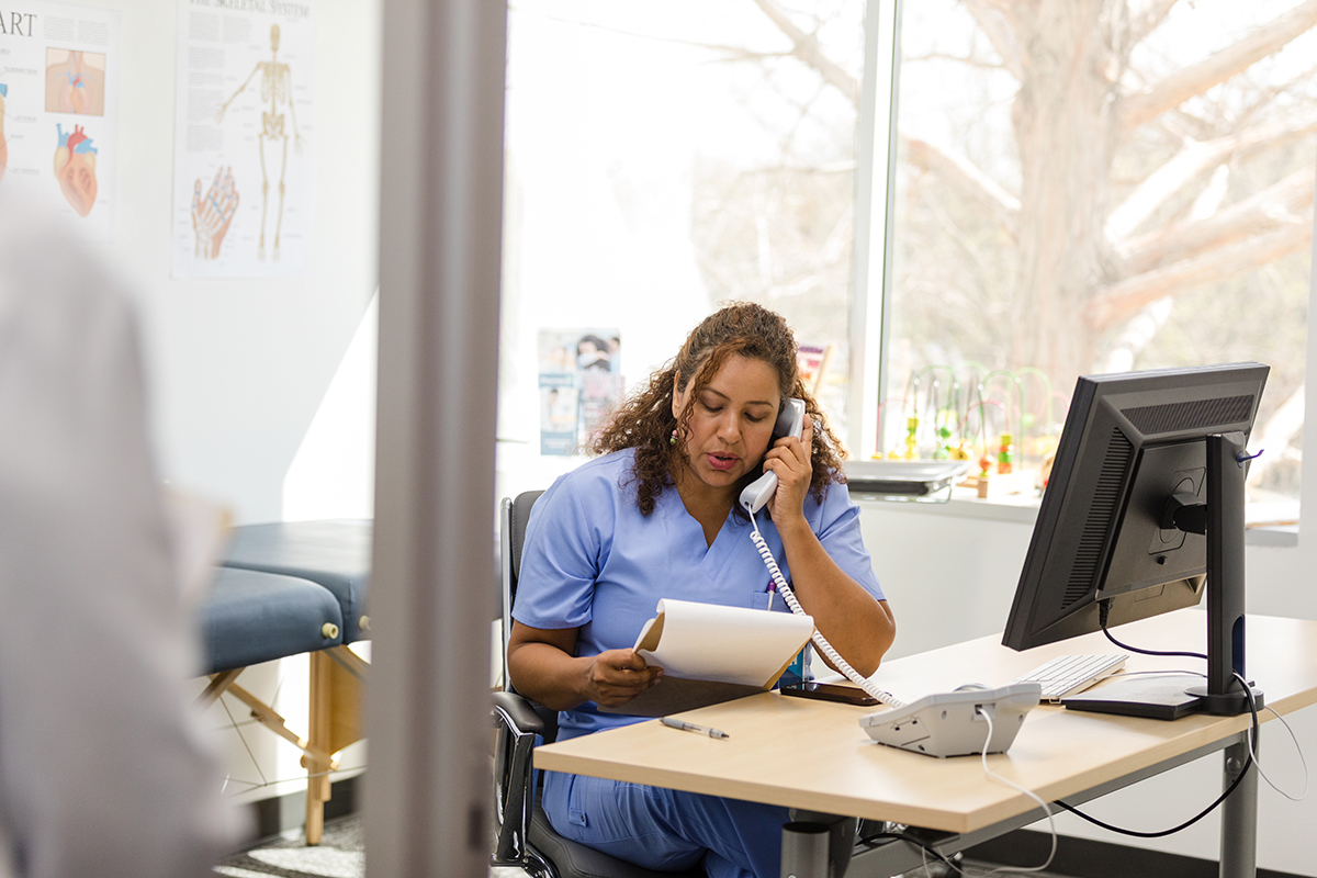 Nurse reviewing notes while on phone call