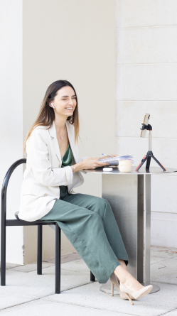 Katerina Gorbacheva sitting on the chair in the city and recording a video