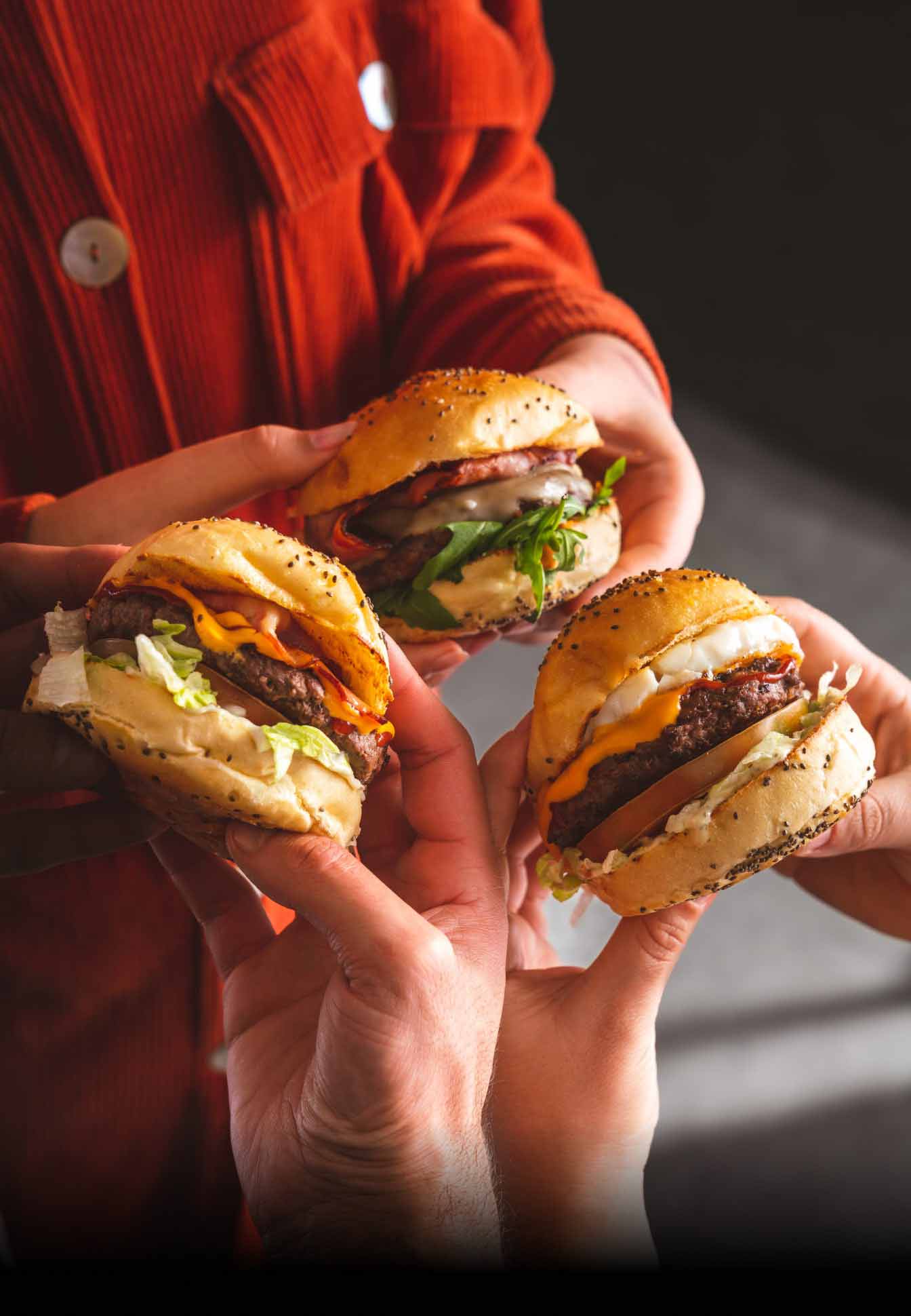 Pessoas com hamburgueres na mão