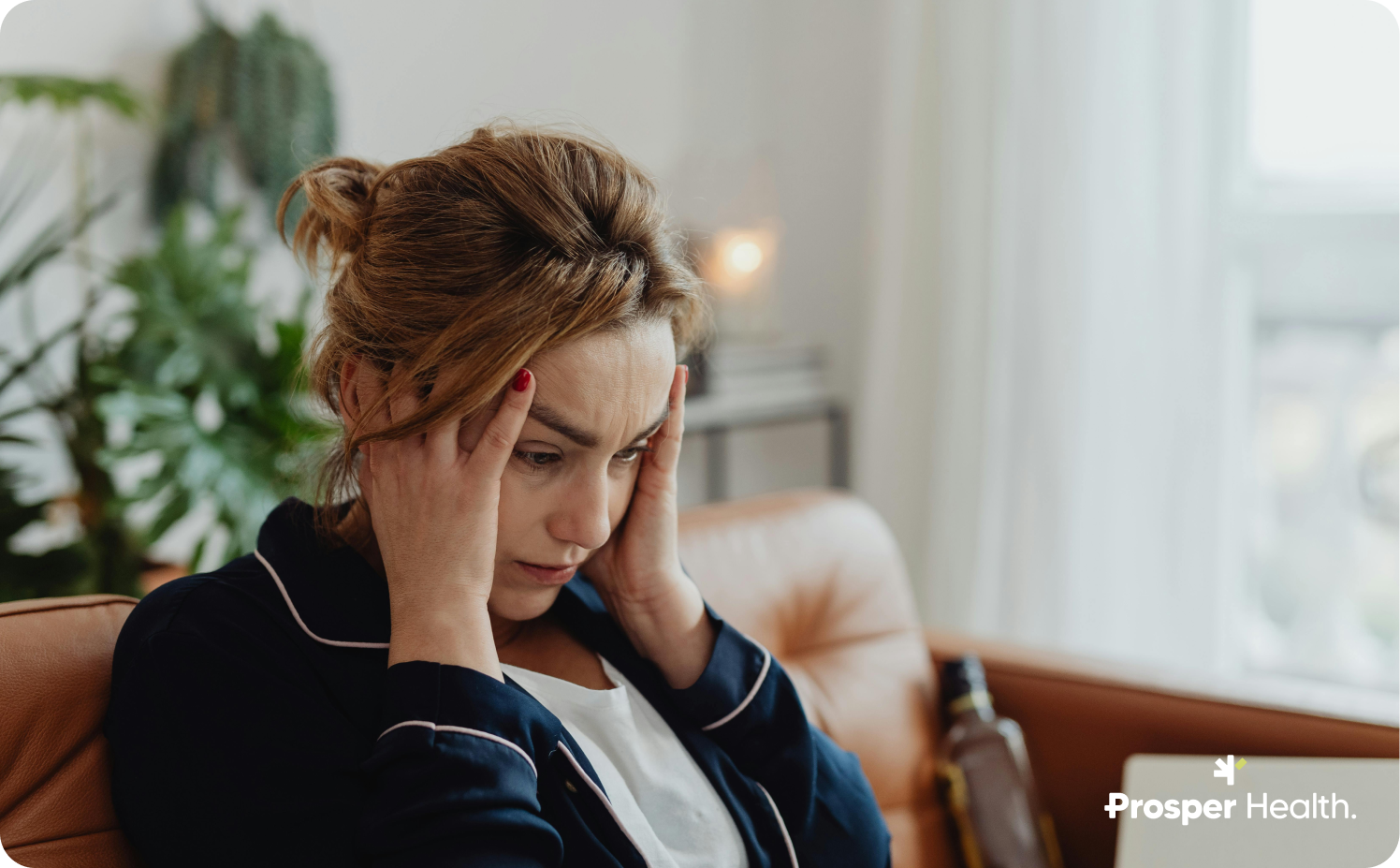 woman sitting in her living room with her head in her hands
