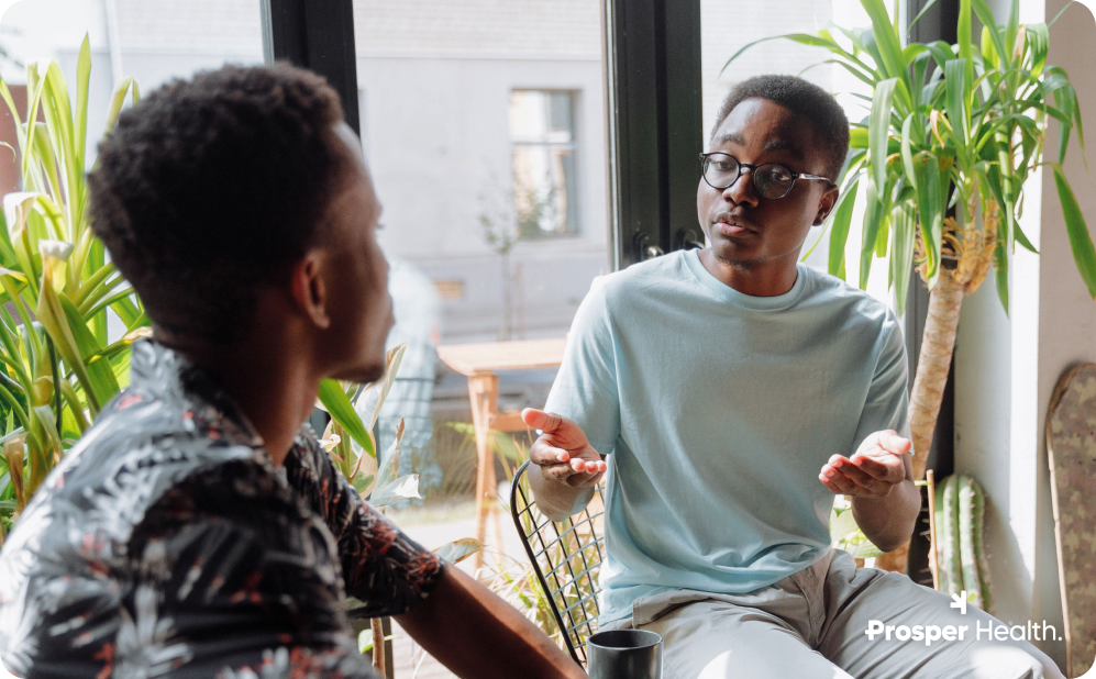 two young Black men talking emphatically with their hands