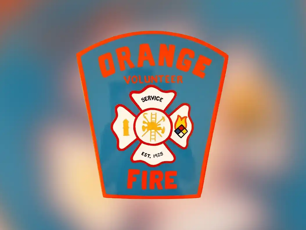 Orange Volunteer Fire Department logo featuring a blue shield with red trim, "Service" motto, and symbols for fire hydrant, fire, and firefighting tools.