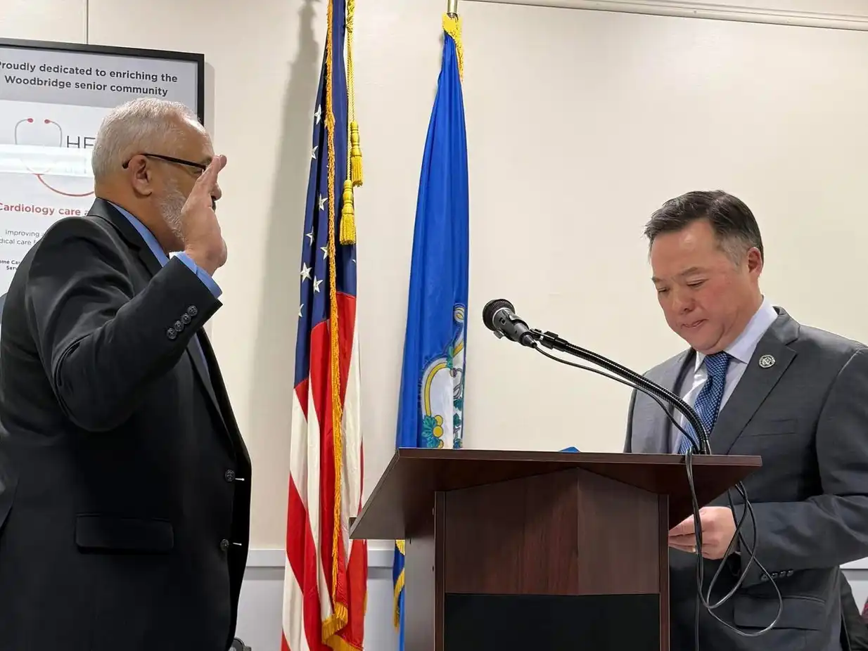 CT Attorney General William Tong swears in First Selectman Mica Cardozo at the 2026 Woodbridge ceremony in front of the American and Connecticut flags.