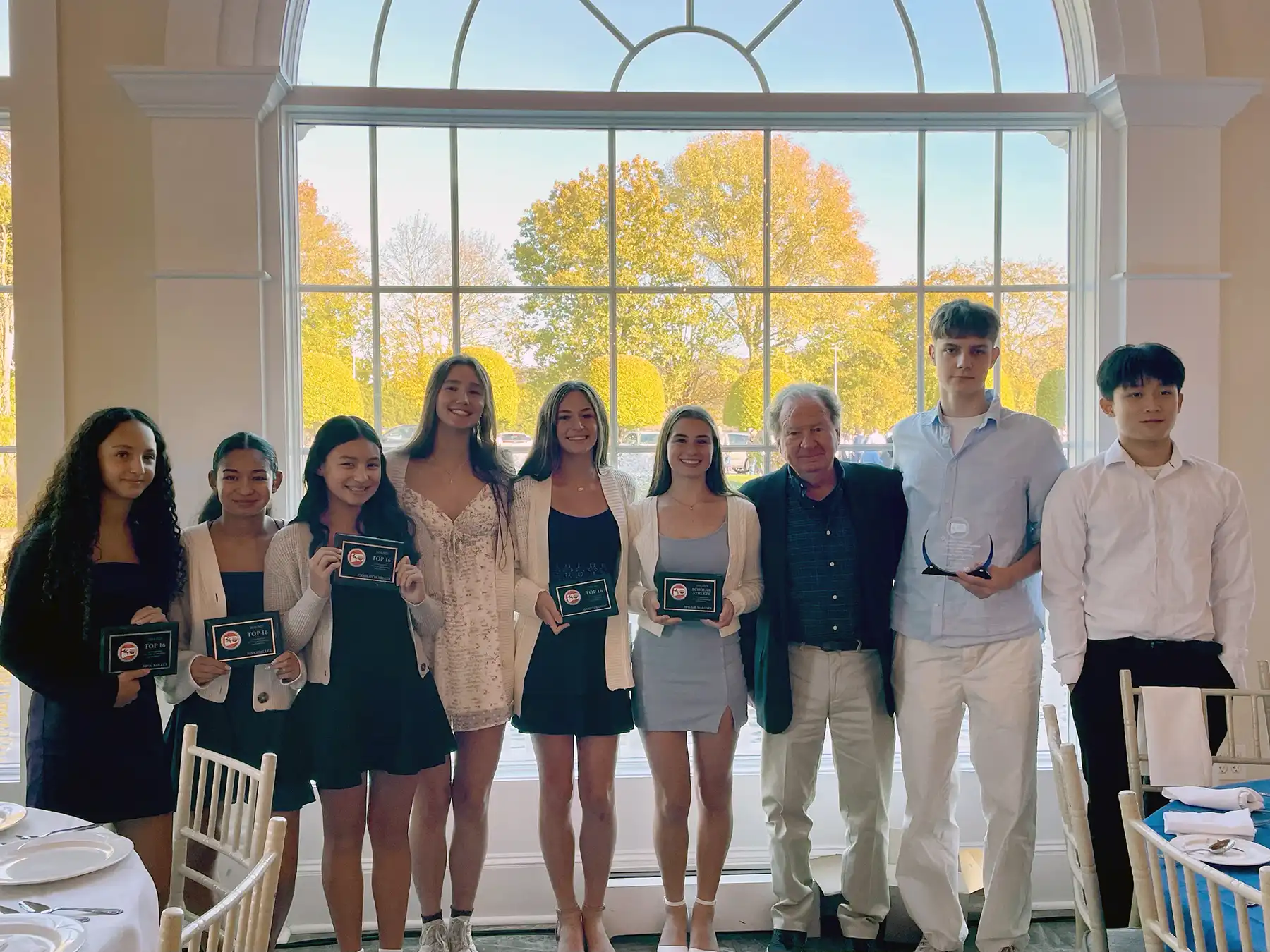 Woodbridge Aquatic Club swimmers pose with awards at the Connecticut Swimming Banquet, celebrating Top 16 times and scholar-athlete achievements.