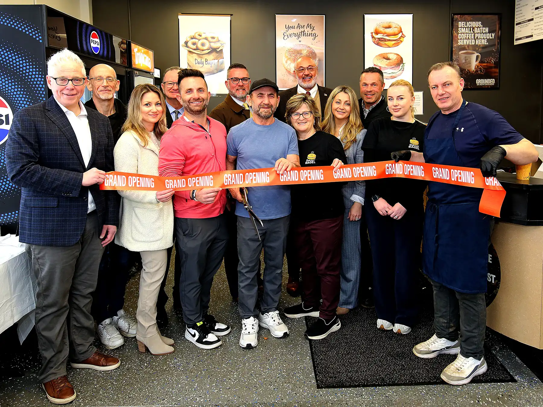 Woodbridge officials and Amity Chamber of Commerce members join Daily Bagel owner Mike Vinca for a grand opening ribbon cutting ceremony.