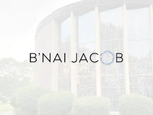 Exterior view of Congregation B'nai Jacob located at 75 Rimmon Road in Woodbridge, CT, featuring a curved brick building and stained-glass windows.