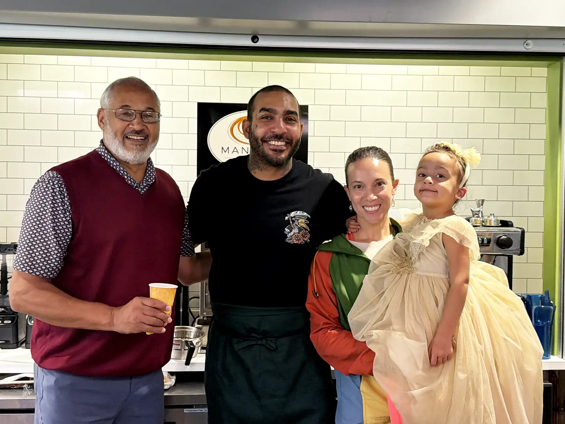 First Selectman Mica Cardozo poses with Mantra’s Café owner Julian Brown and his family at the Woodbridge Community & Cultural Center open house.