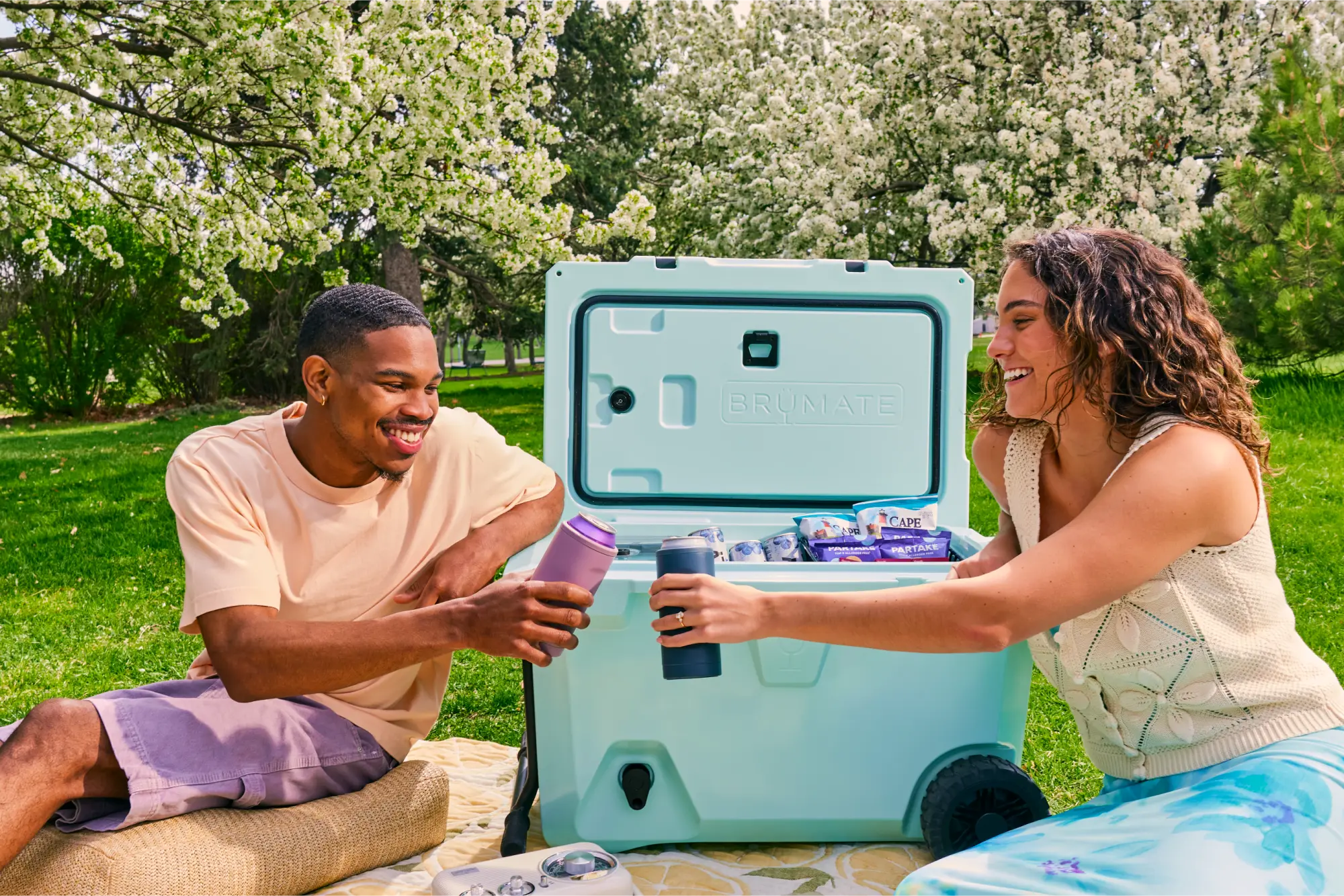 Two individuals at a park with BruMate cooler
