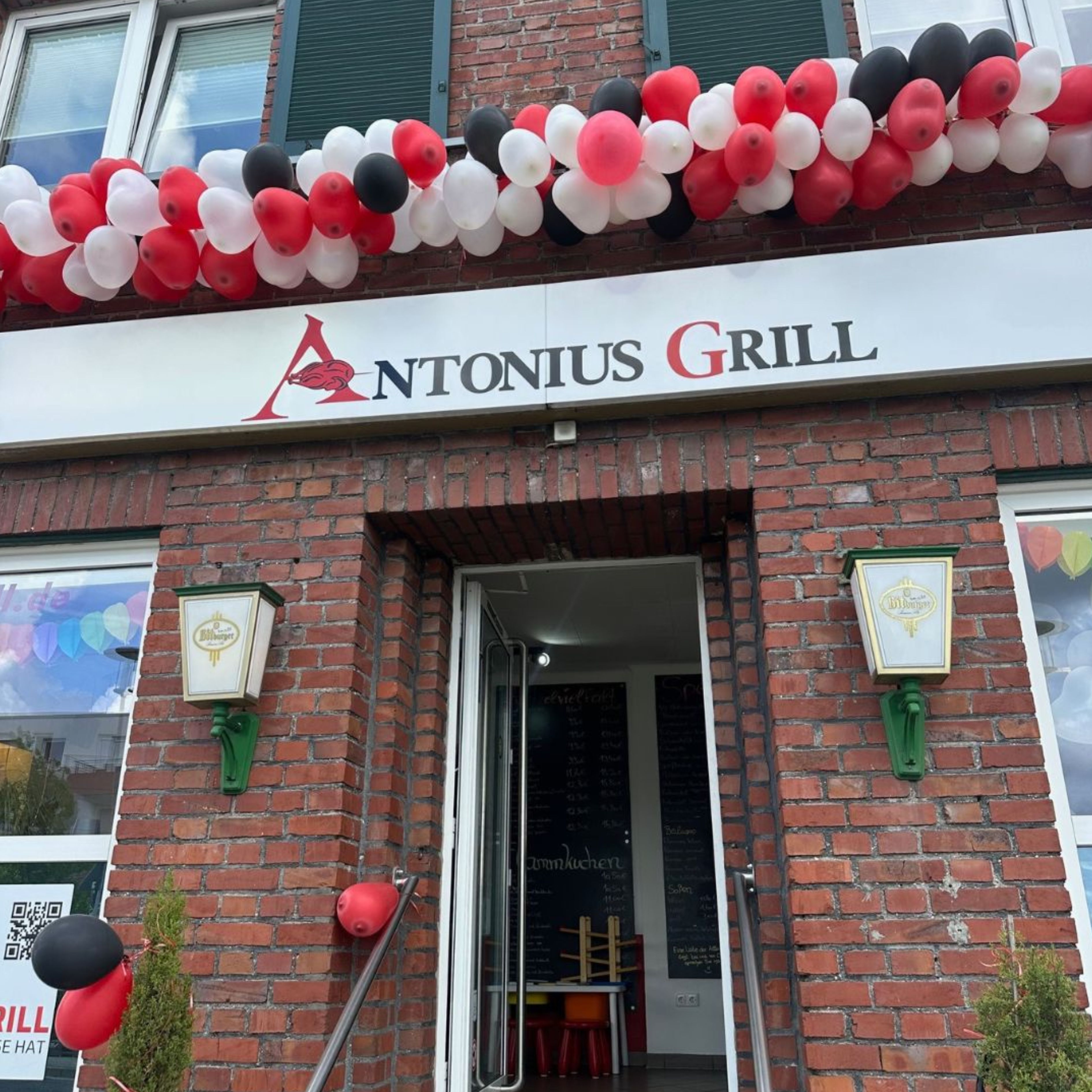 Außenansicht vom Antonius Grill geschmückt mit roten und weißen Ballons.