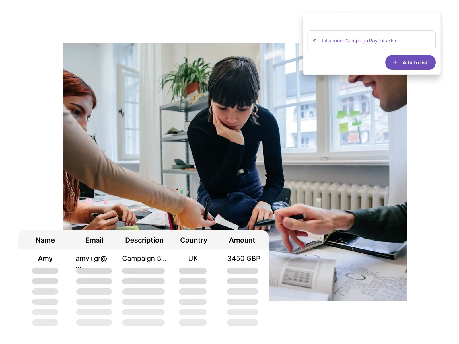 Three people discussing and pointing at documents on a table in a bright office with windows and plants.