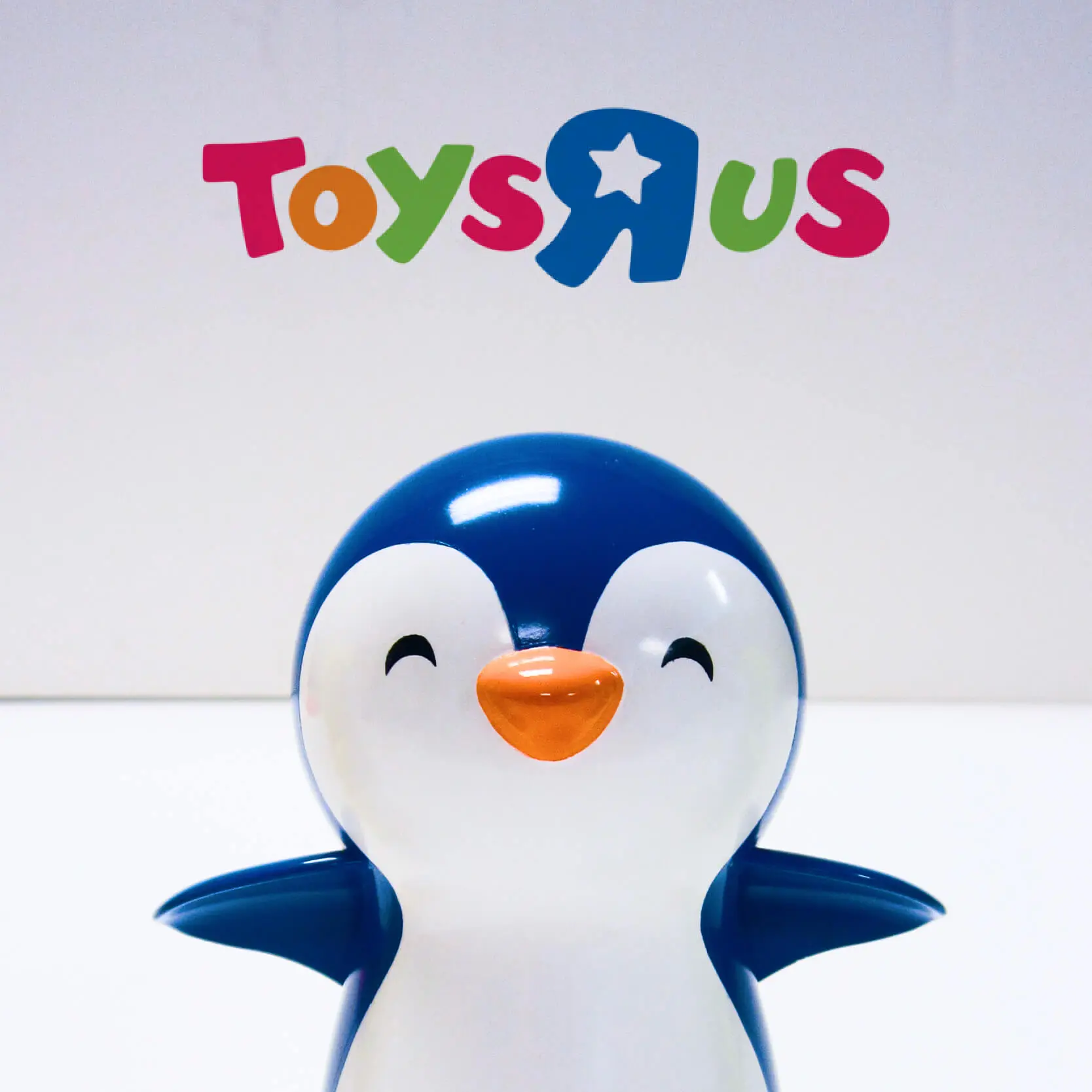 Toy penguin with Toys R us logo in the back