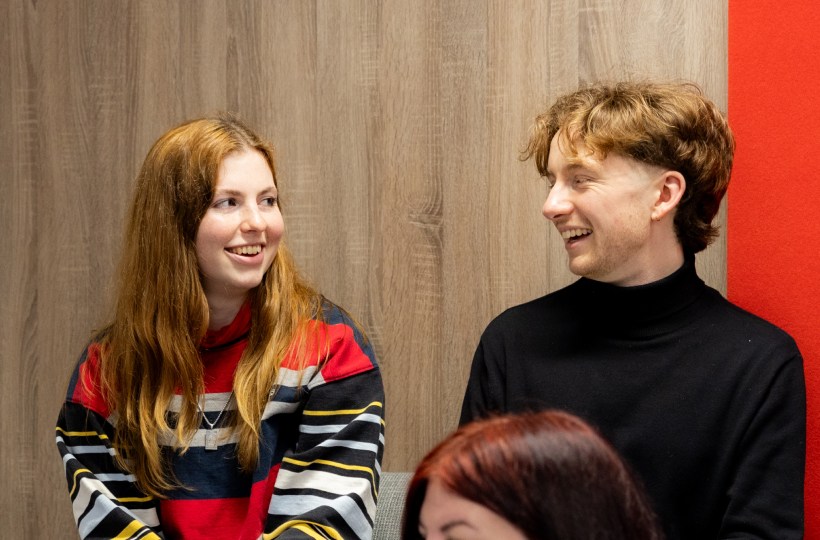 Two ICS-translate linguists sharing a conversation in the office