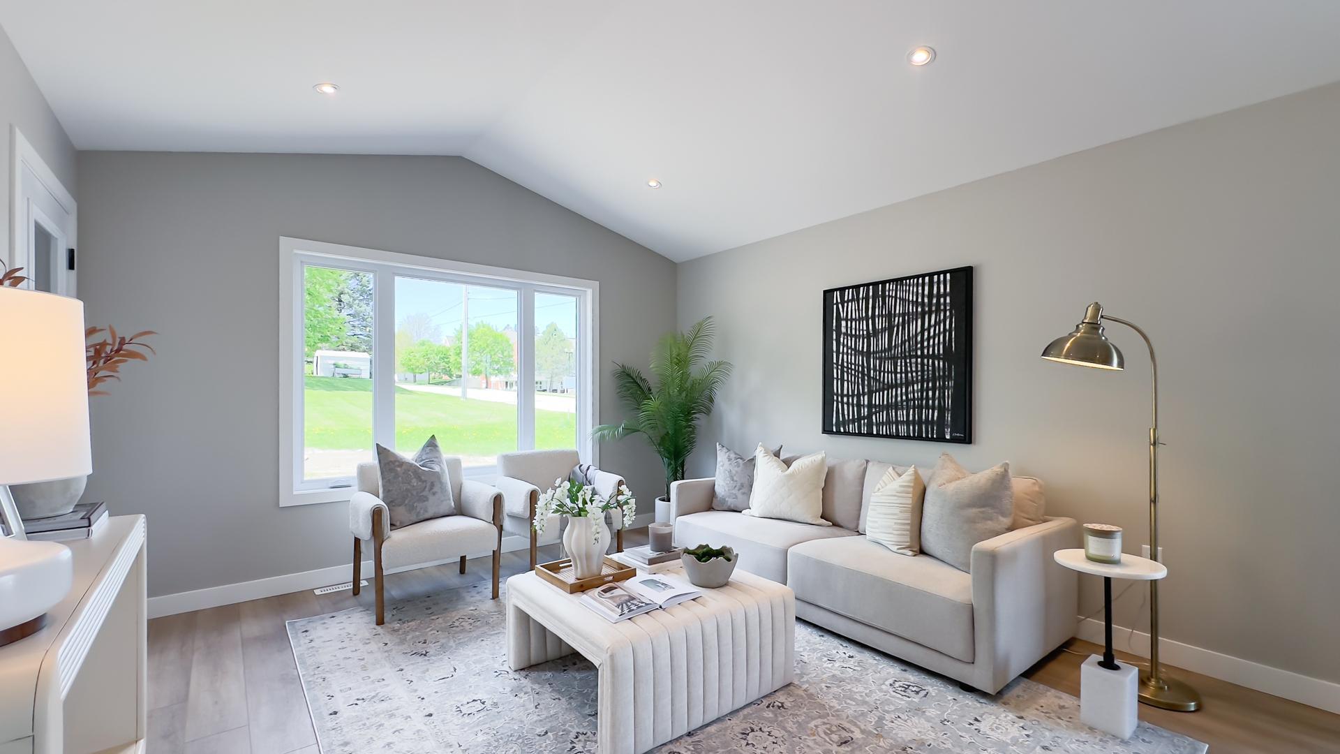 Open concept living room with large windows and vaulted ceilings
