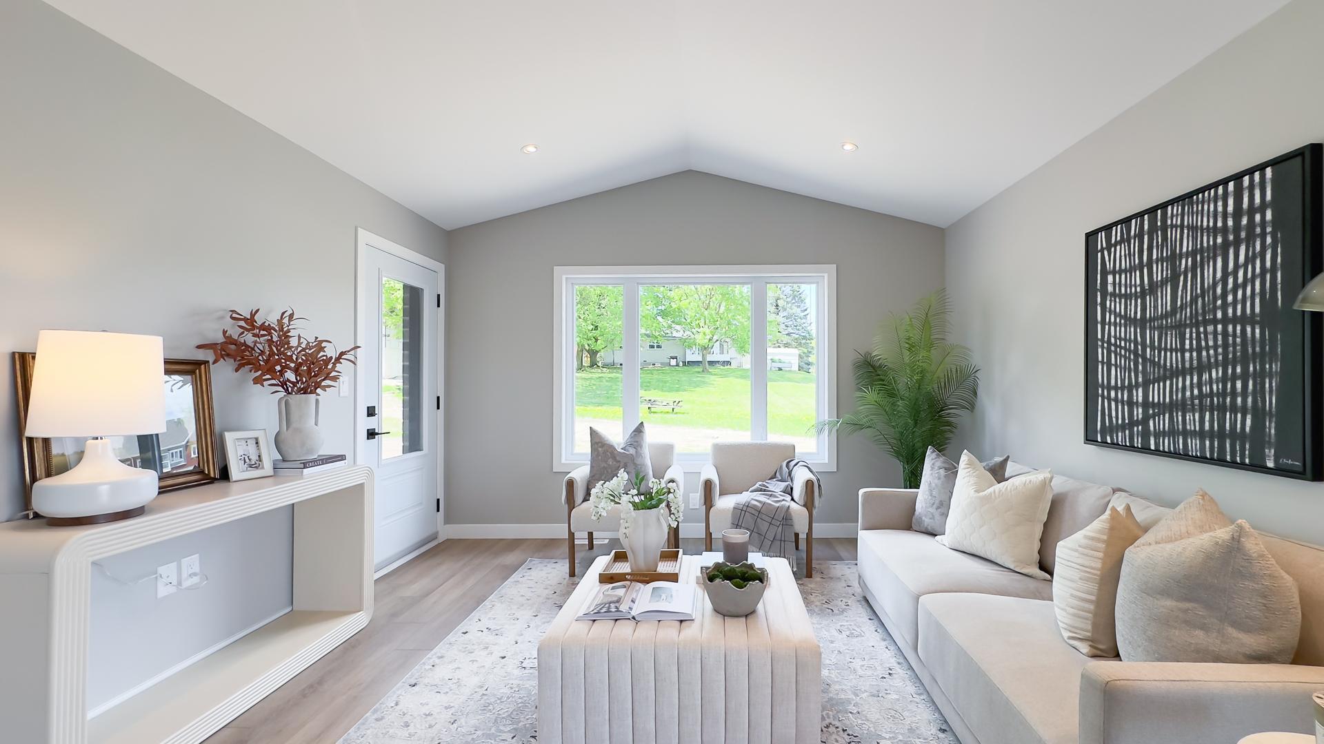 Open concept living room with large windows and vaulted ceilings