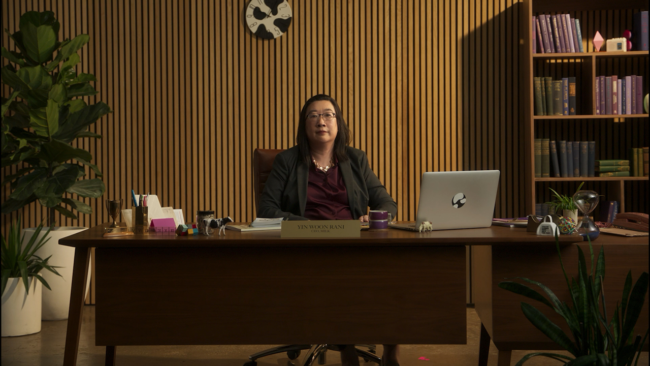 A tall building with an advertisement a rock climbing wall, a man standing on top, and the slogan "You're gonna need Milk for that. Got Milk?" 