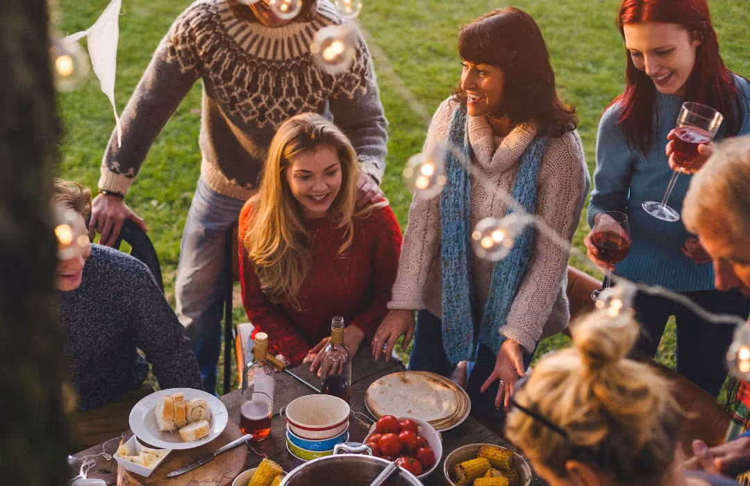 A cosy outdoor gathering with friends and family enjoying food, drinks, and warm conversation under string lights. A bespoke HOMETAINMENT experience in London, perfect for private dining, intimate celebrations, and exclusive home events.