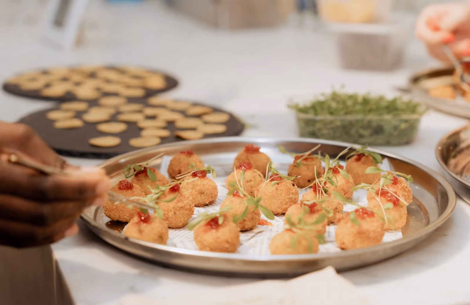 Fried canapes on a silver platter in a kitchen being prepared to be served to guests