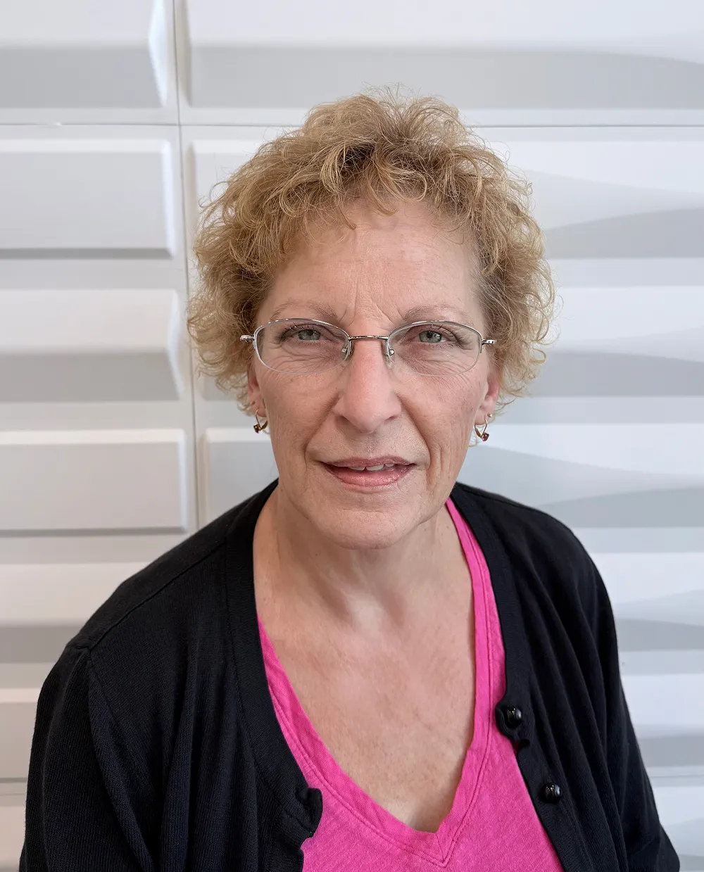 A profile picture of Maria Yablonski in front of a white wall with a raised wave pattern.