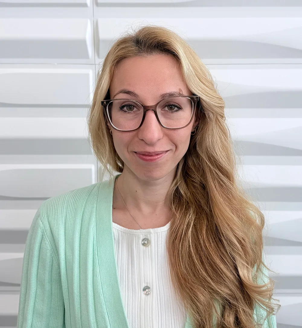 A profile picture of Veronika Shulgina in front of a white wall with a raised wave pattern.