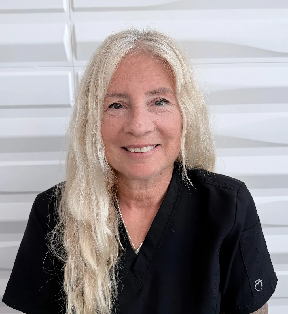 A profile picture of Nicole Laliberte in front of a white wall with a raised wave pattern.