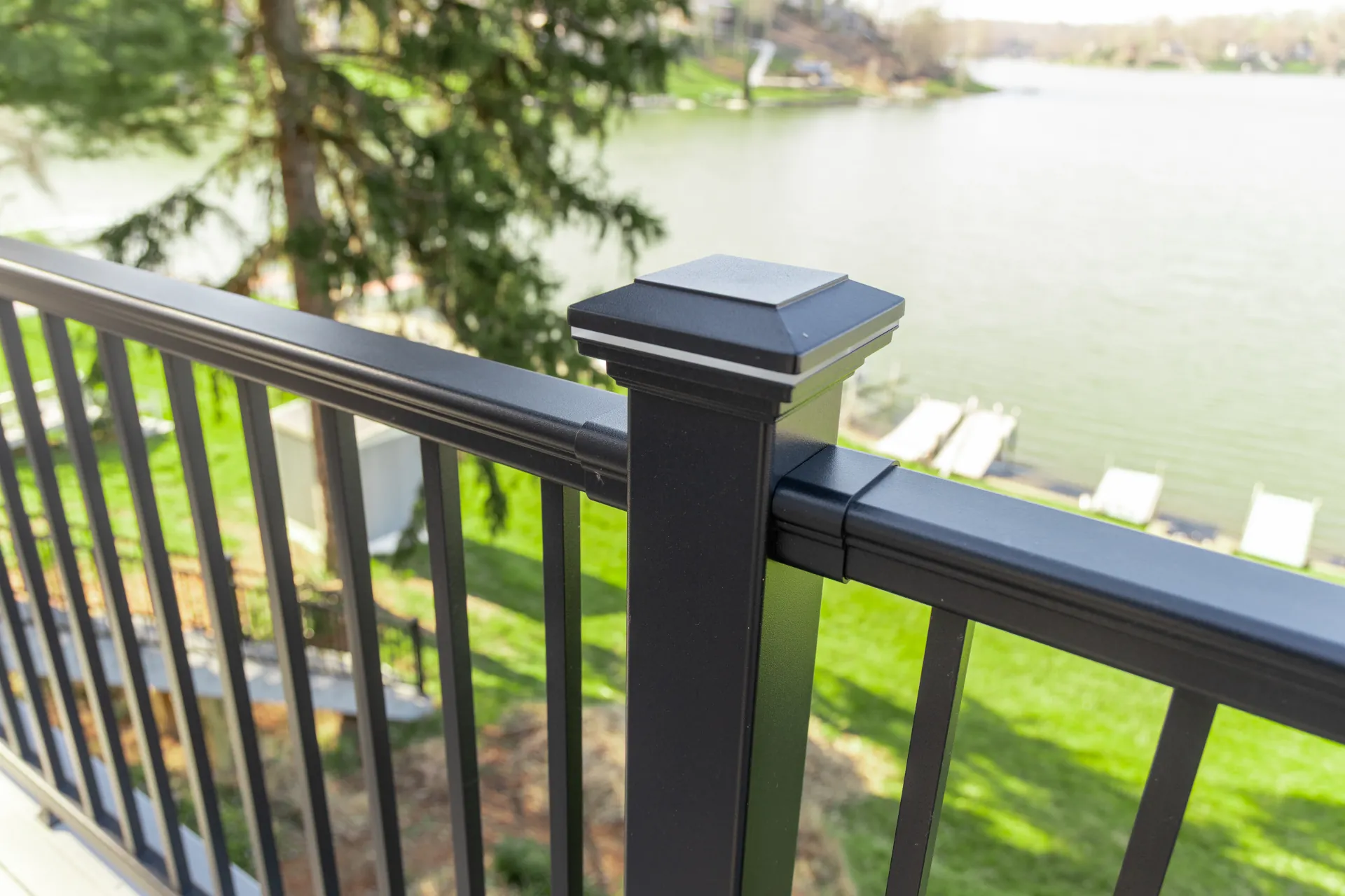 Black aluminum deck railing overlooking a lake, offering a modern design with unobstructed waterfront views.