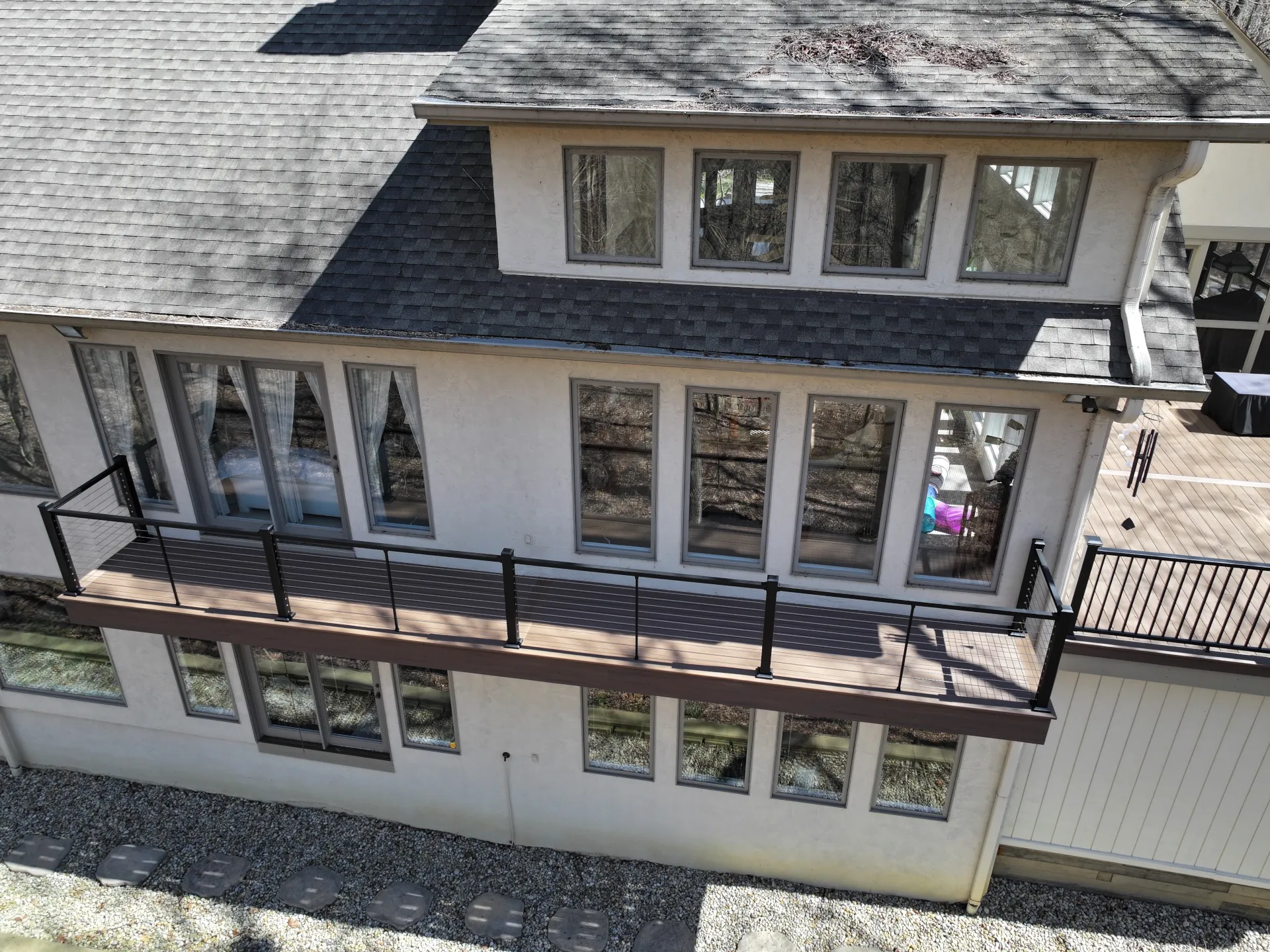 Elevated composite deck featuring black cable railing for open views and a sleek, contemporary outdoor living space.