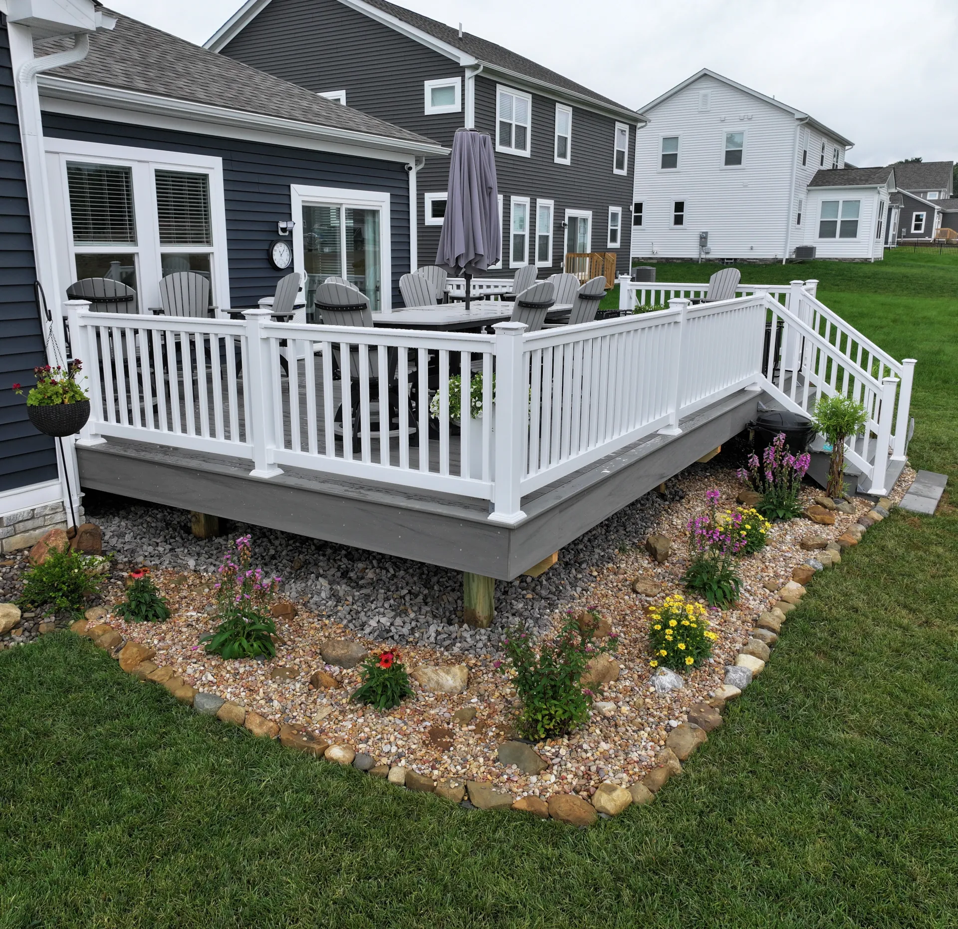Sea Salt Gray composite deck with white vinyl railing and landscaped garden border in Pataskala, Ohio.