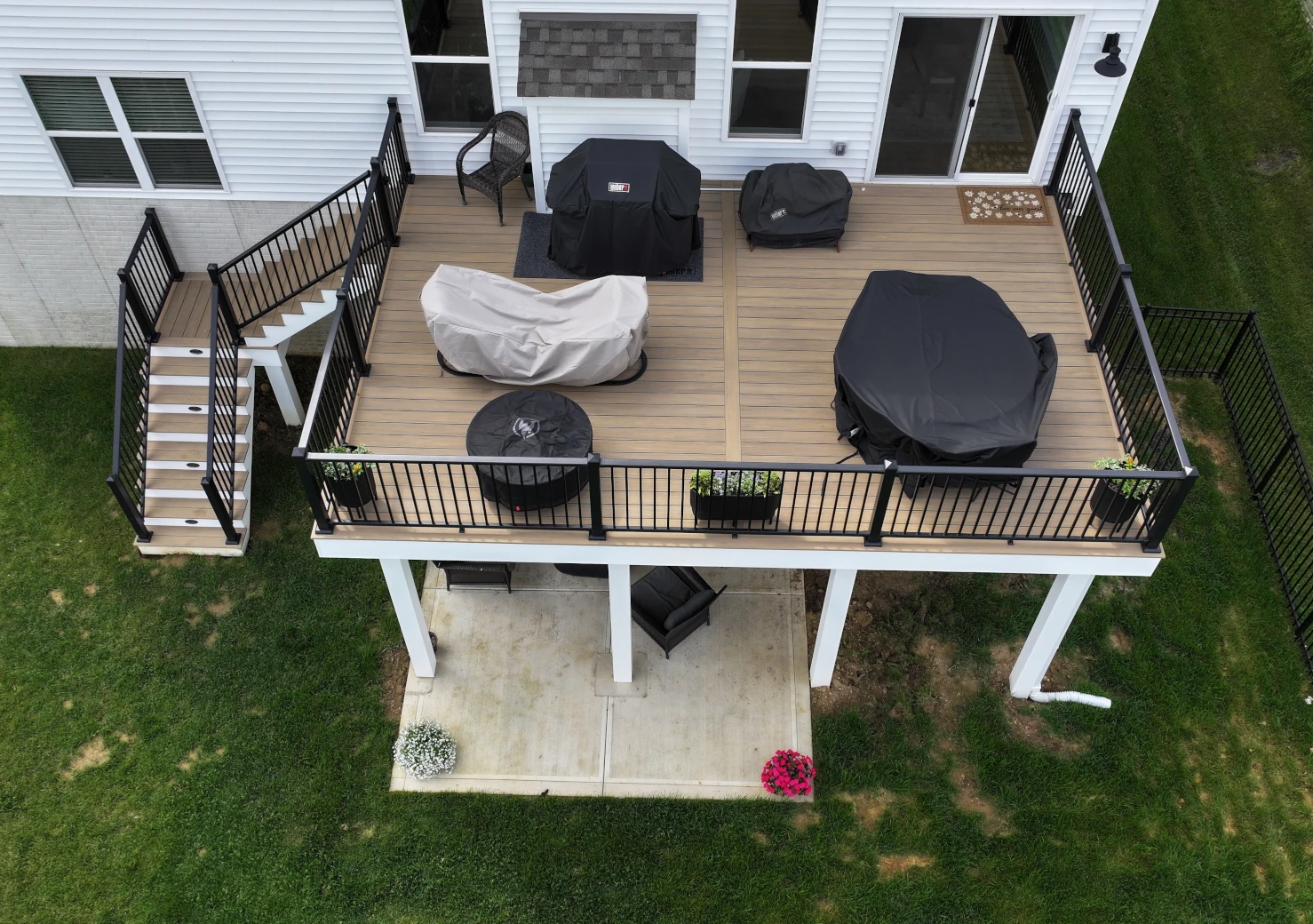Elevated PVC deck with Weathered Teak decking, black aluminum railing, and white AZEK stair risers in Plain City, Ohio.