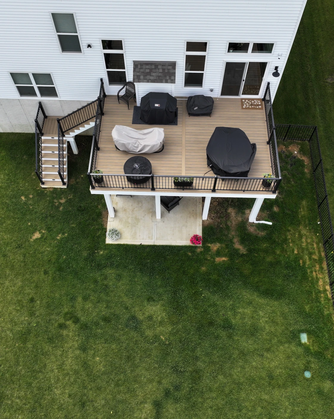 Elevated PVC deck with Weathered Teak decking, black aluminum railing, and white AZEK stair risers in Plain City, Ohio.