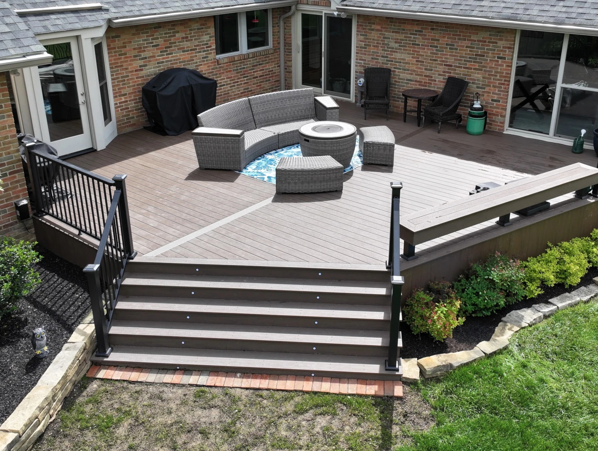 Dark Cocoa composite deck with black aluminum railing, wide stairs, and integrated stair lighting in Dublin, Ohio.