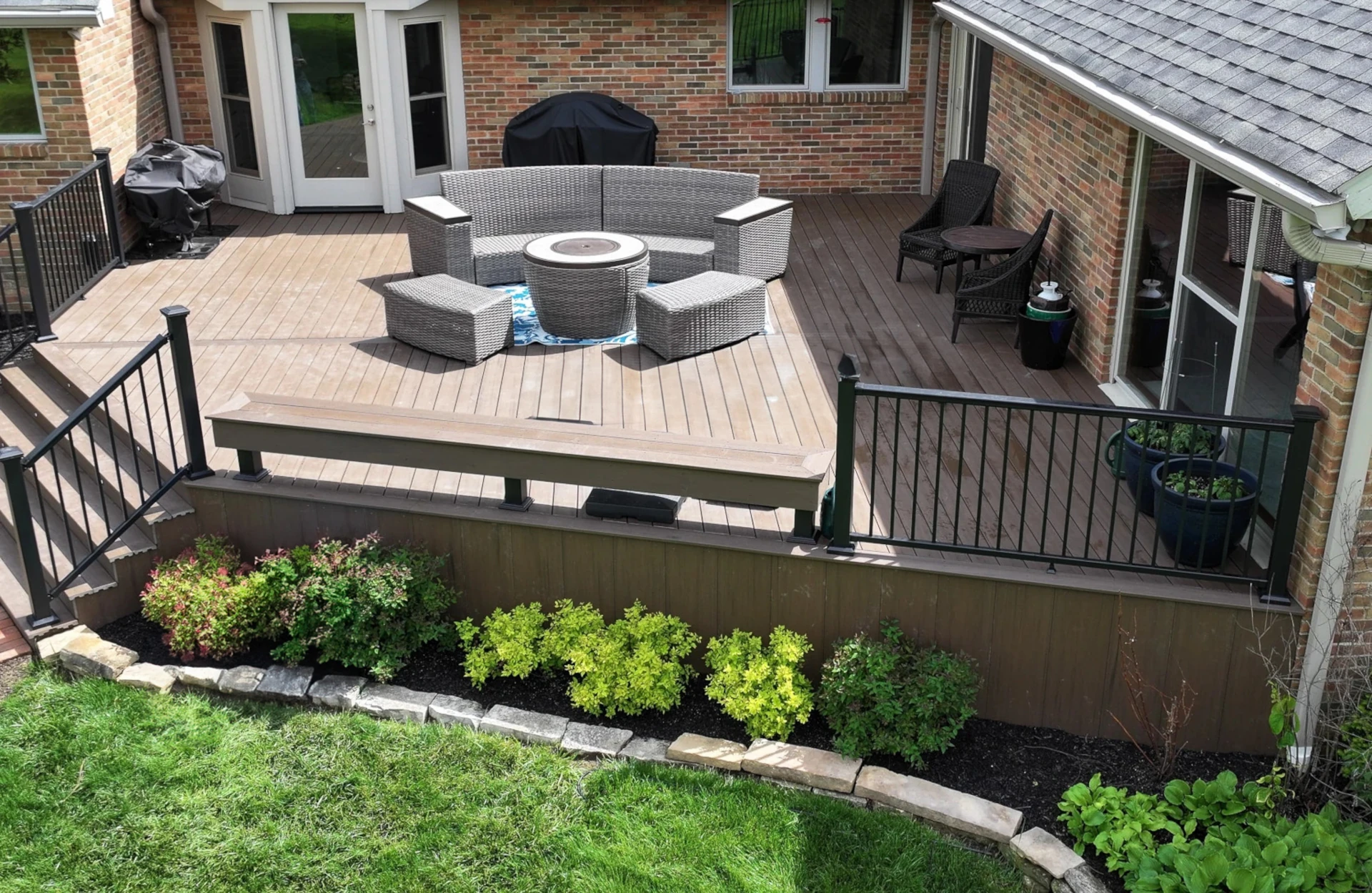 Prime+ Dark Cocoa composite deck with coordinating skirting, black aluminum railing, and landscaped border in Dublin, Ohio.