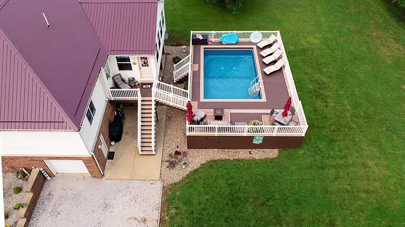 Aerial view of a Brownstone and Kona composite pool deck with white vinyl railing in Sardis, Ohio.