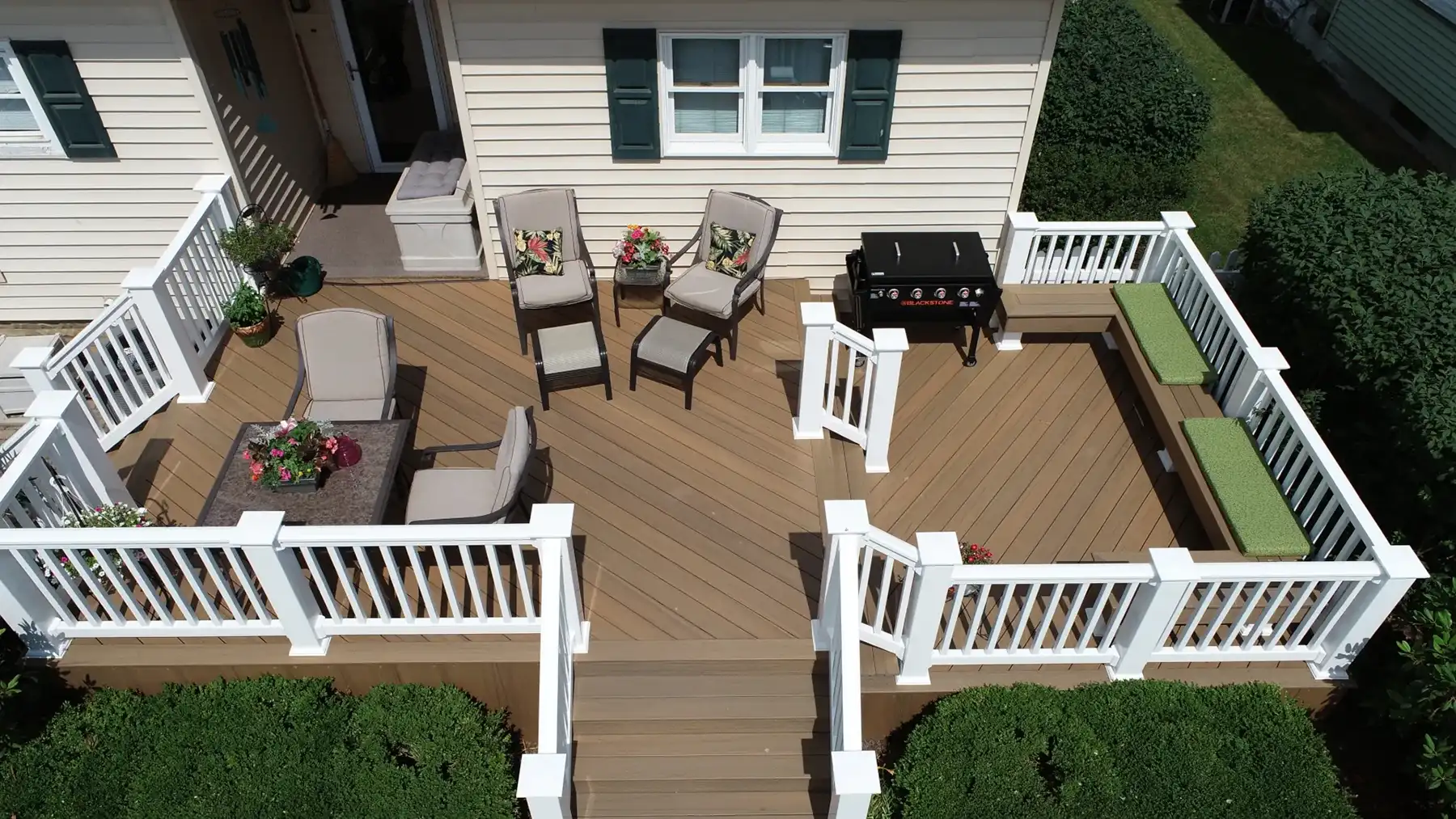 Aerial view of a rebuilt Coconut Husk composite deck with white vinyl railing, wide stairs, and custom built-in benches in Tiltonsville, Ohio.