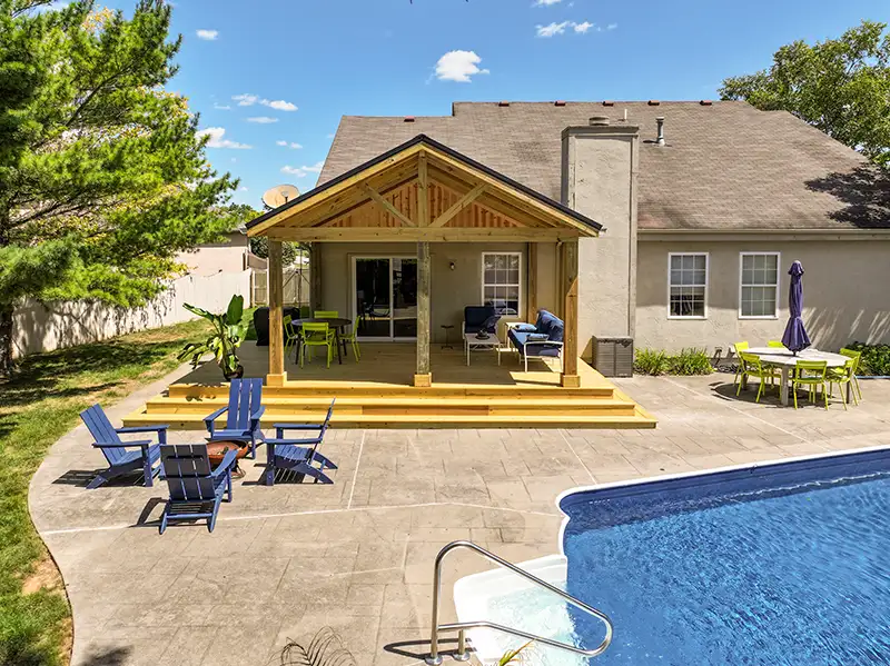 Poolside covered porch with pressure-treated wood decking, exposed timber framing, and wide steps in Grove City, Ohio.