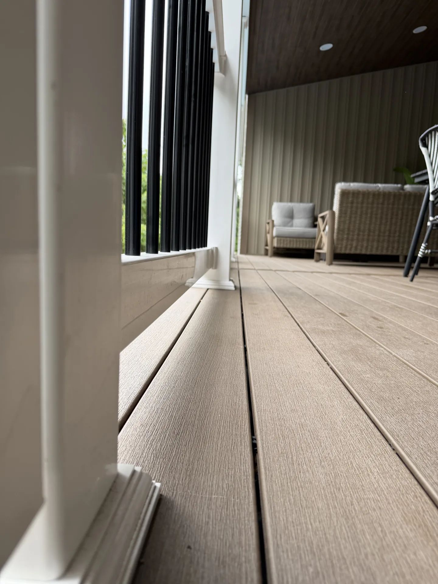 wv.jpg Close-up of Dark Oak composite decking and white railing on a Wheeling deck
