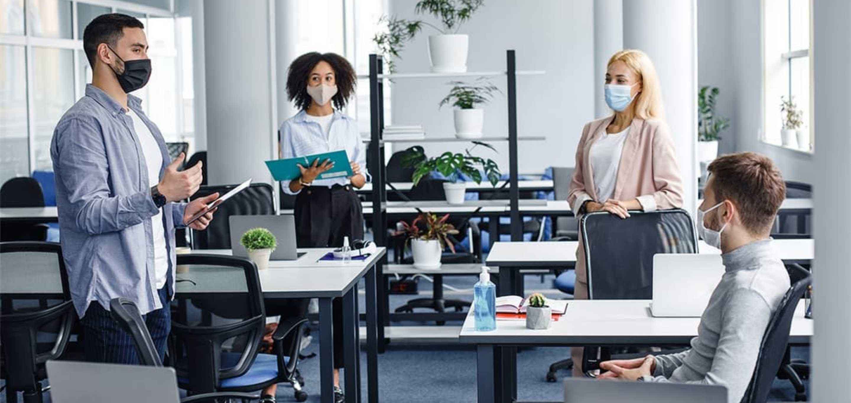 Team members socially distanced in an office wearing face masks