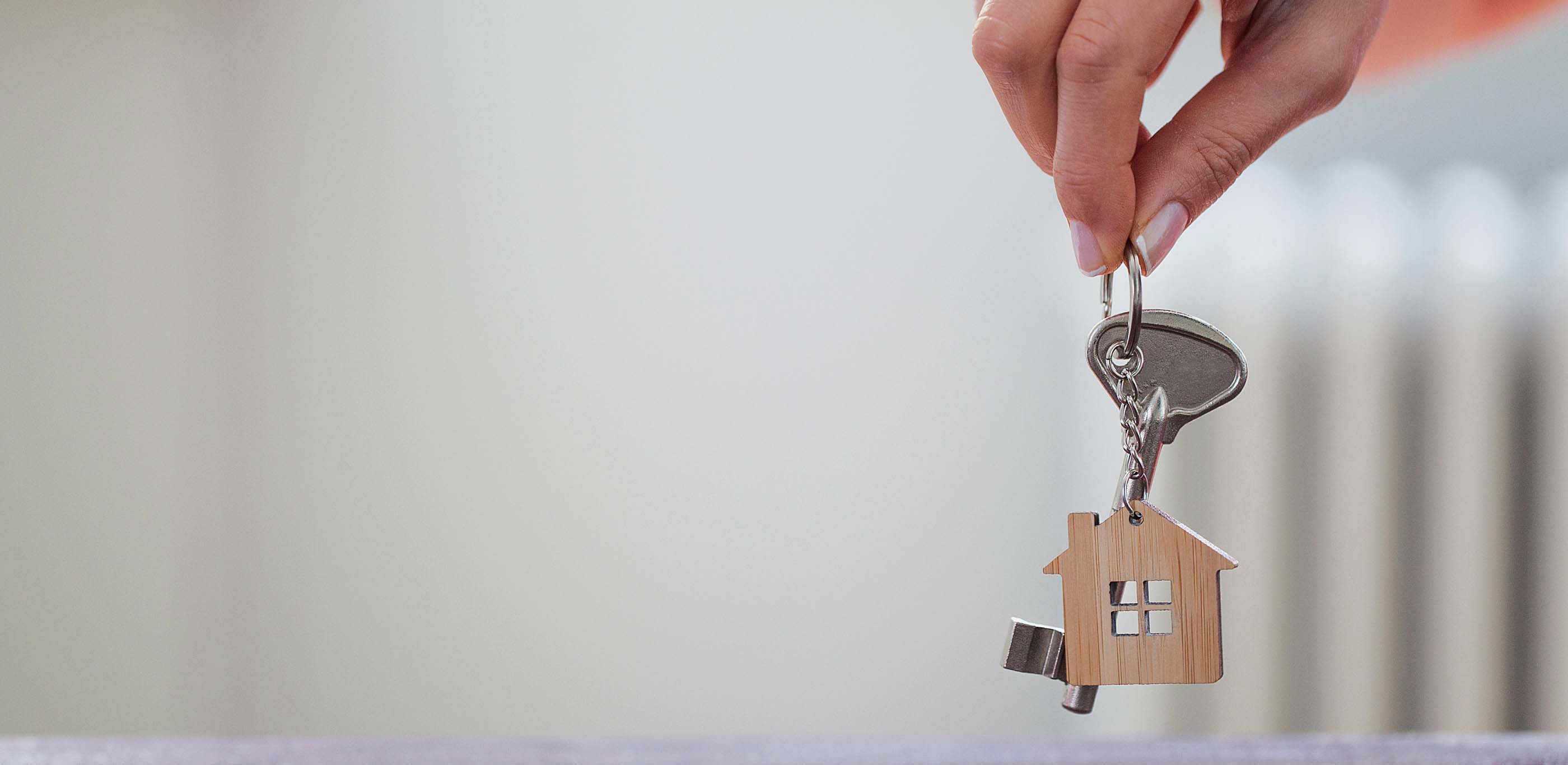 Hand holding keys and house keychain