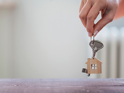 Hand holding keys and house keychain