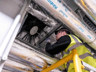 System Hygienics engineer carrying out ventilation duct cleaning in a commercial building.