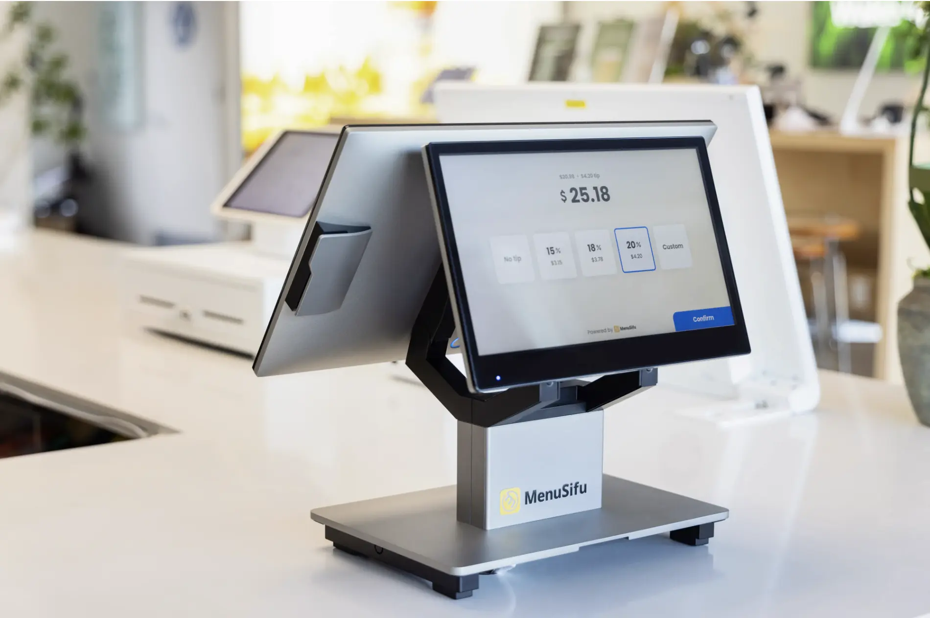 Close-up of the MenuSifu dual-screen POS system at a restaurant counter, displaying payment and tip options for a seamless checkout experience.