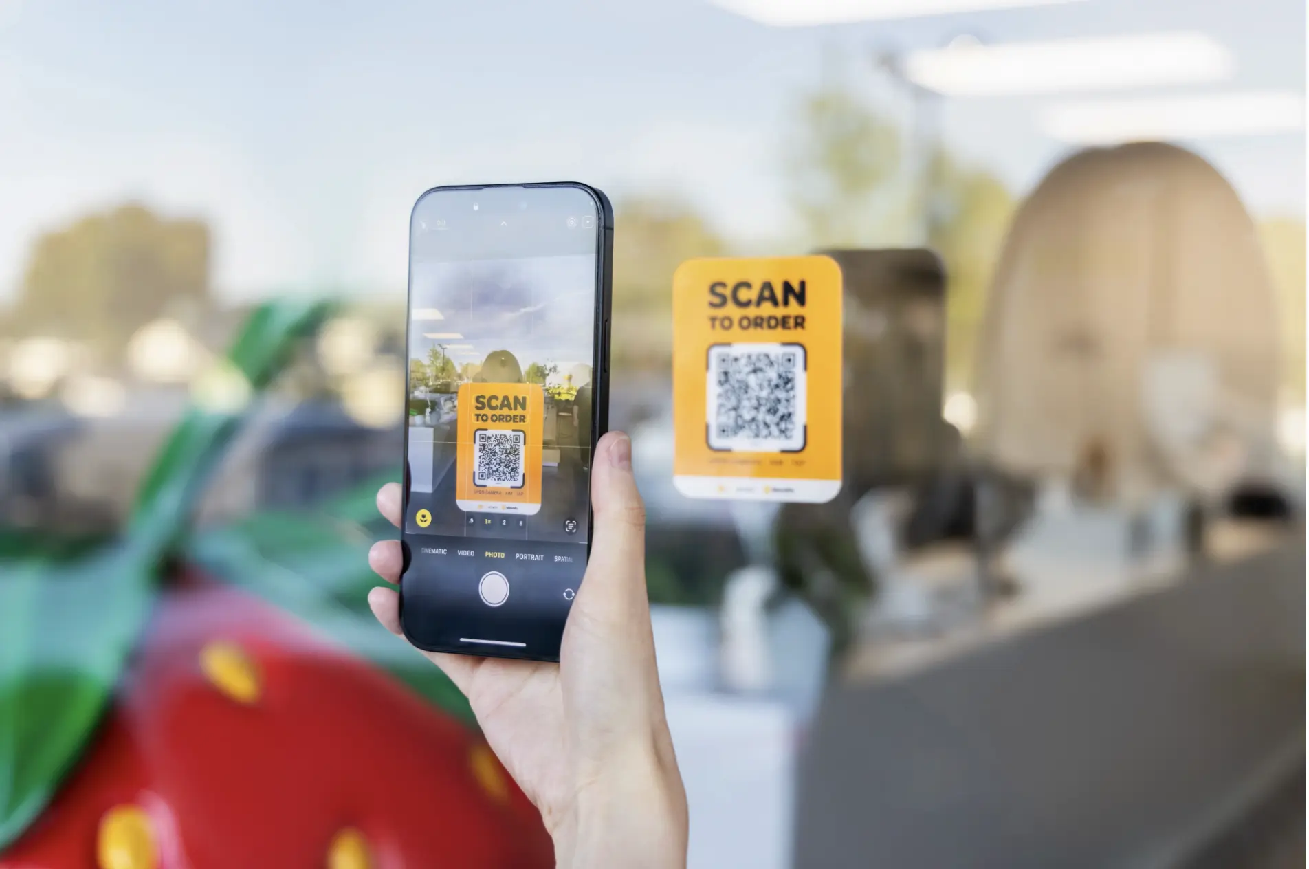 A customer scans a “Scan to Order” QR code on a restaurant window using their phone to place a contactless order through MenuSifu’s digital ordering system.
