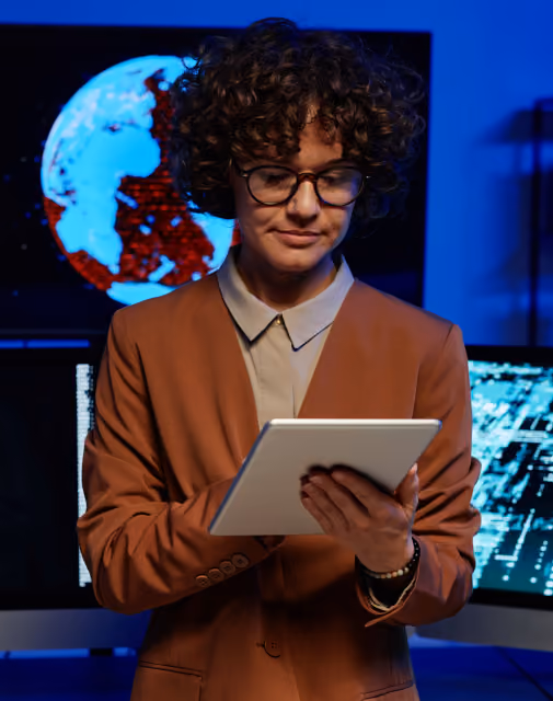 Technology leader reading on a tablet in front of a data visualization