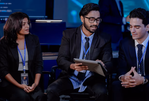Three business leaders reviewing a tablet together during a meeting