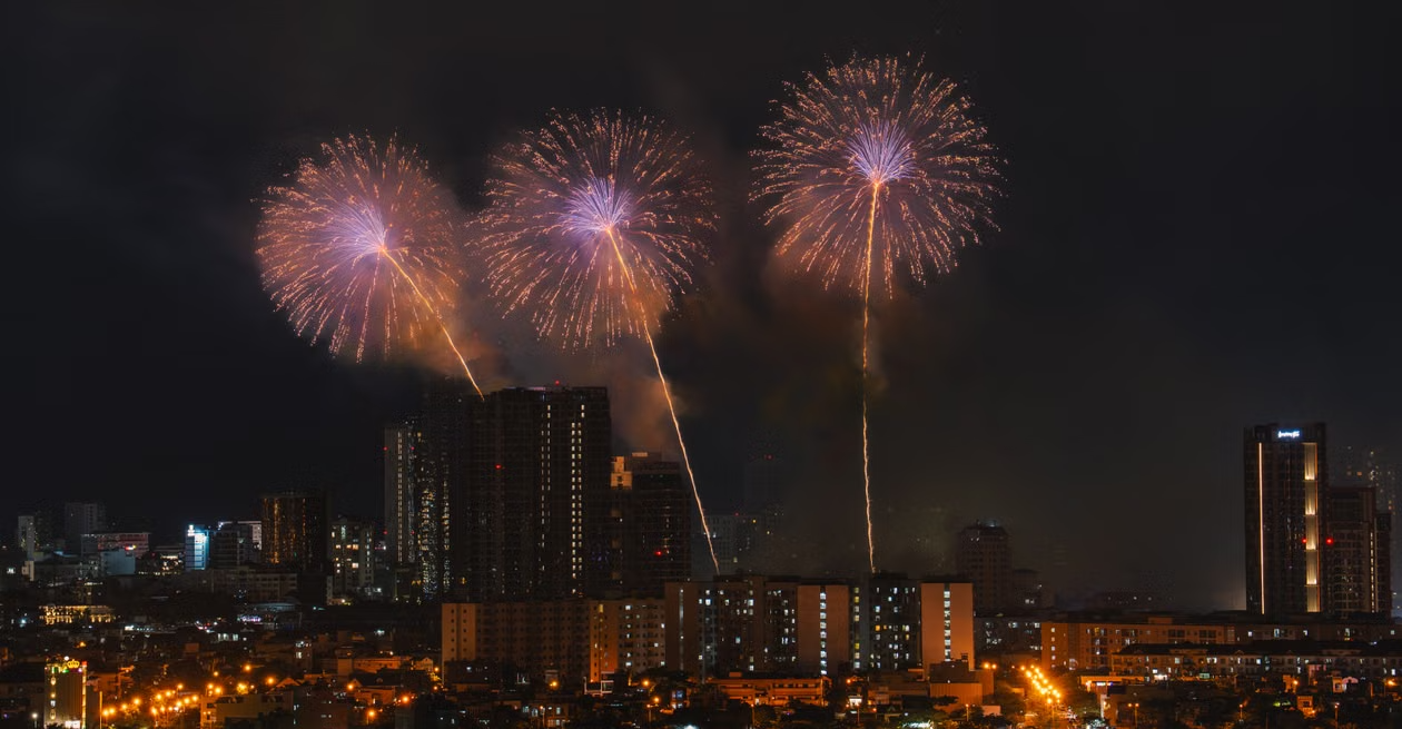 Colorful fireworks lighting up the night sky above a city skyline.