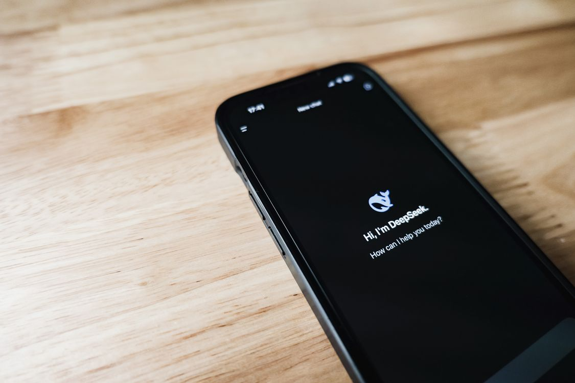 Close-up of a smartphone showing the DeepSeek AI chat app with a conversation interface.