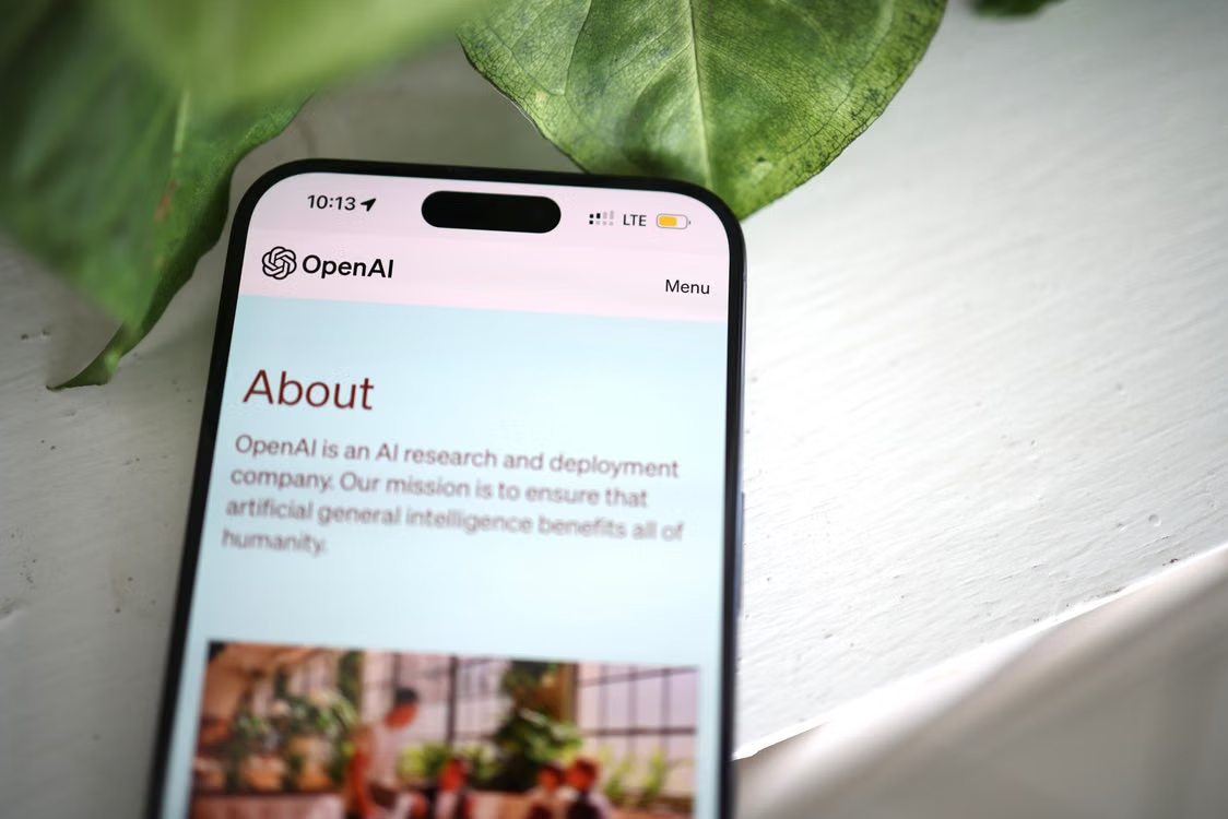 Smartphone displaying the OpenAI website, representing AI platforms and mobile access to autonomous agents.